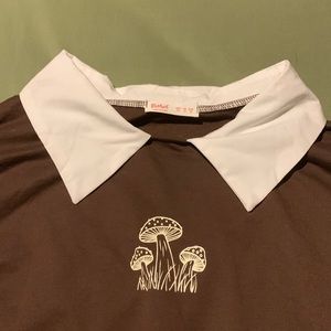 Brown shirt with mushroom and white collar.